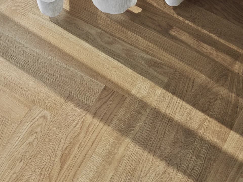 Sildebensgulv i naturfarvet eg med sollys hen over brædderne